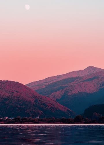 Evening moonrise over majestic mountains.