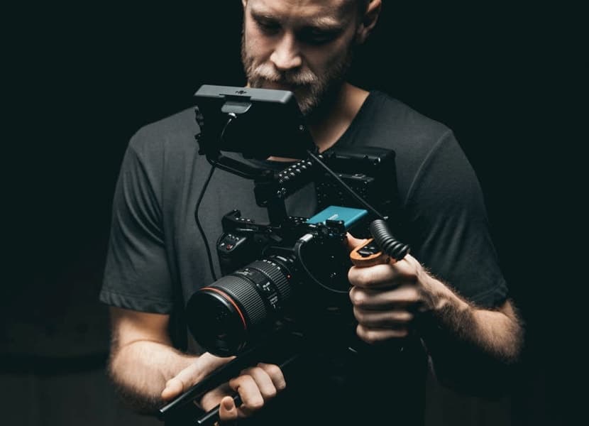 A man holding a camera and looking at it.