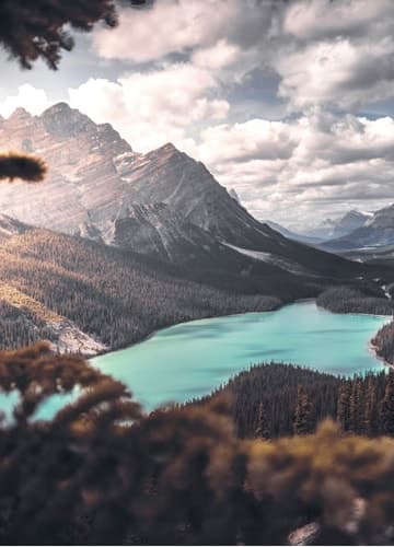 A serene lake nestled amidst majestic mountains and lush trees, creating a picturesque landscape.
